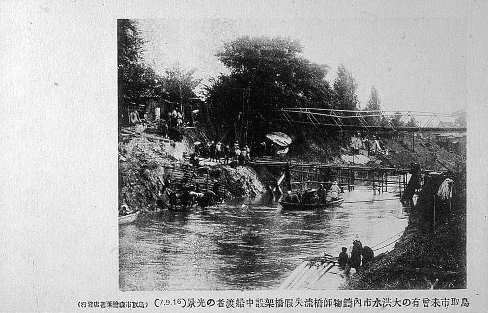 鳥取市未曾有の大洪水市内鑄物師橋流失仮橋架設中船渡者の光景's image 1